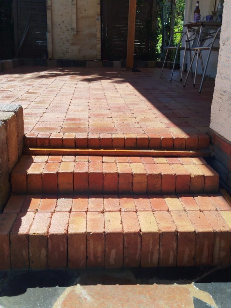 Neu verlegte Terrassenstufen aus rotem Pflasterstein